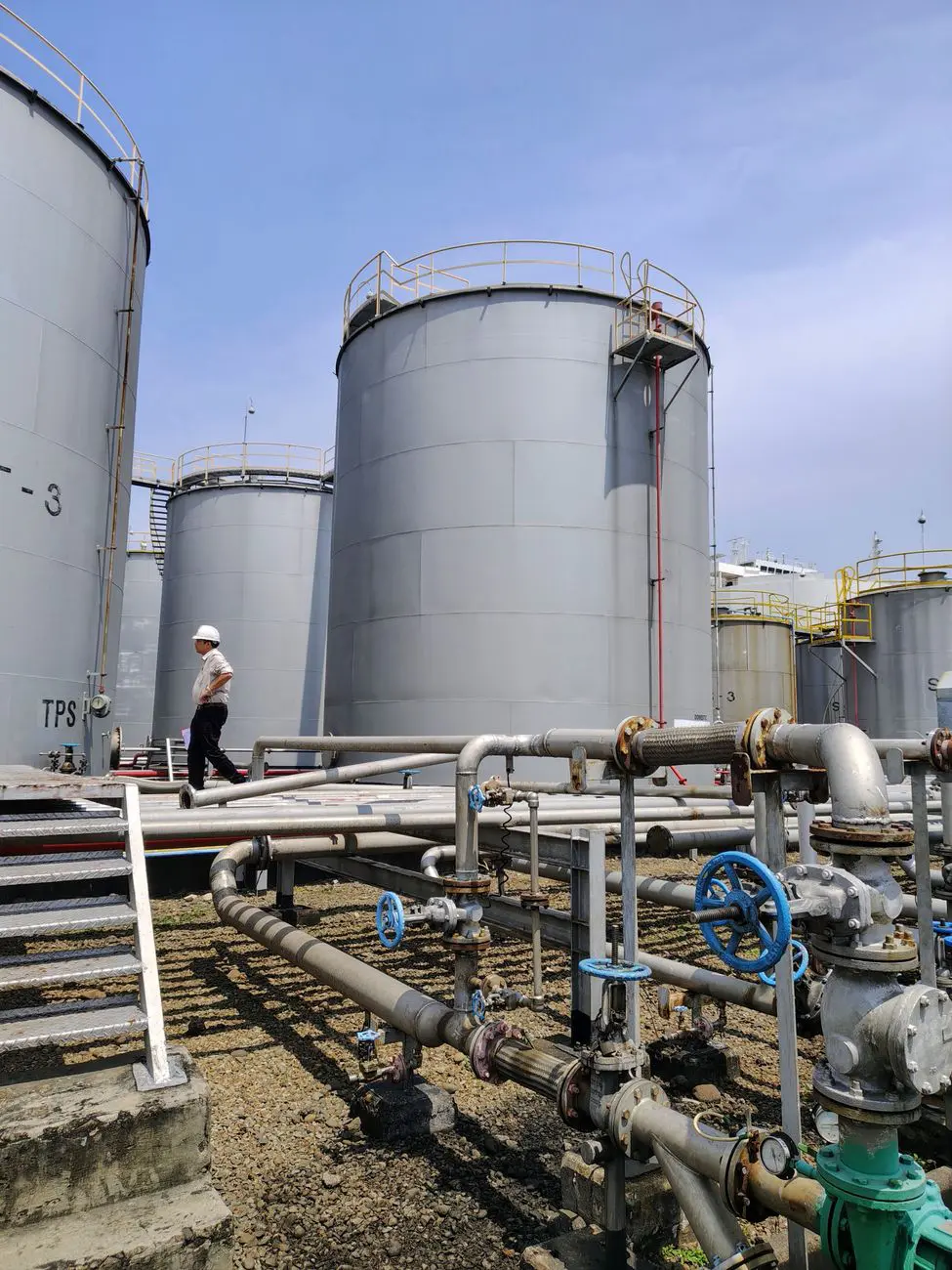 industrial oil storage tanks under clear sky